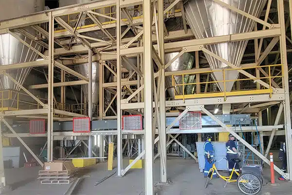 Two KWS Drag Conveyors Transfer Wood Ash from Silos Above